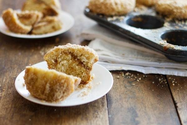 Coffee cake muffin in two pieces on a white plate.