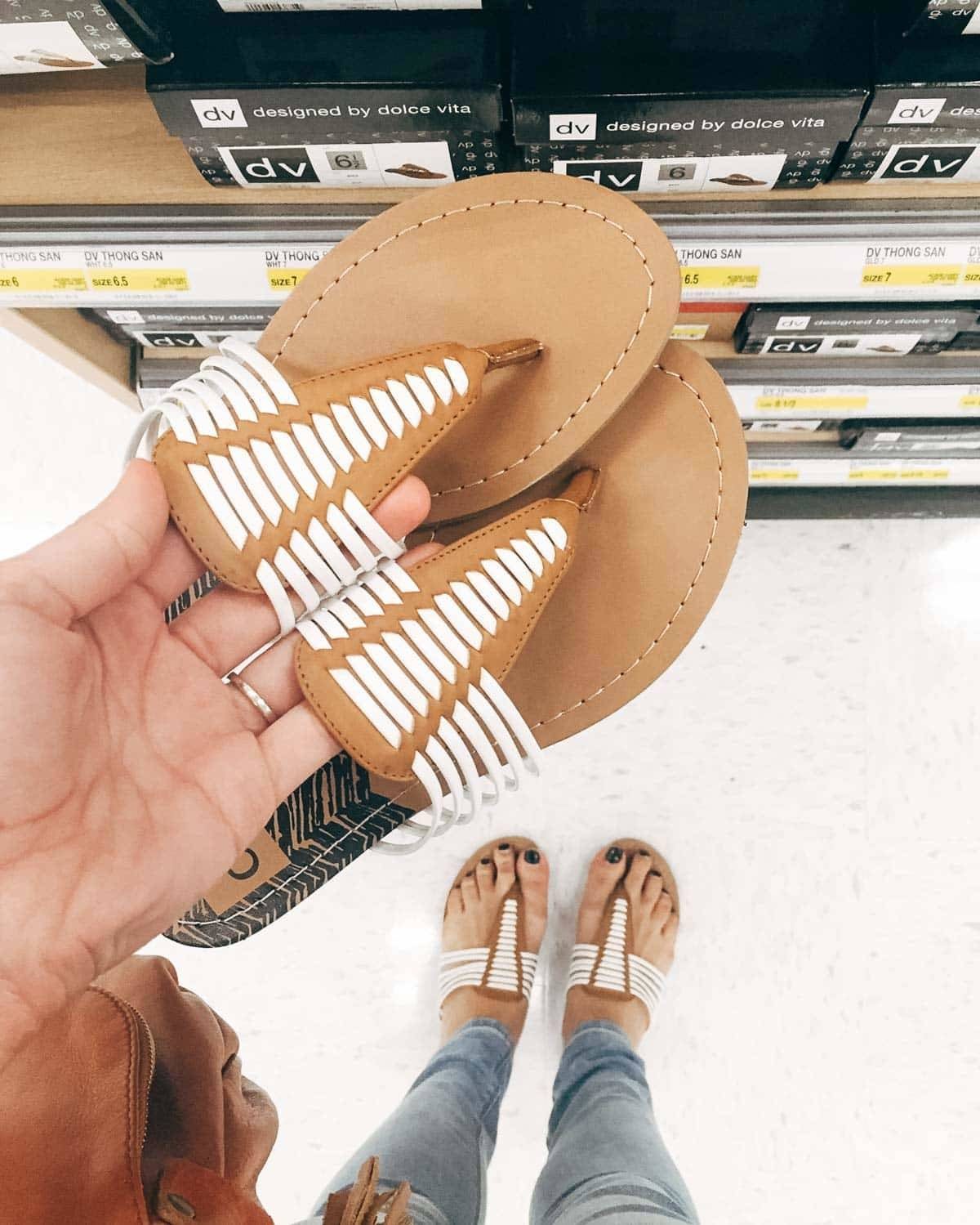 Hand holding a pair of sandals.